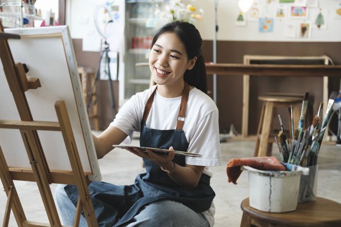 Crafting Inspiration. Female Artist Sketching and Painting in Workshop