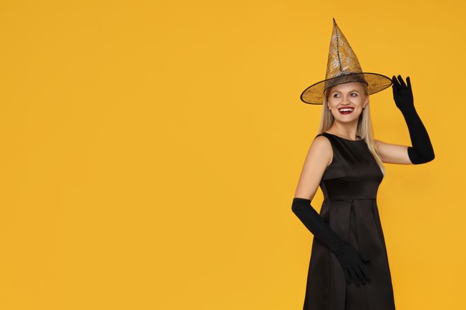 A woman in a Halloween costume on a yellow background