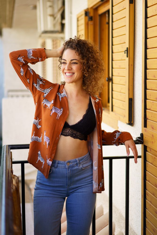 Happy woman casually standing on her balcony