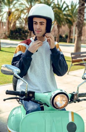 Man in motorcycle adjusting helmet