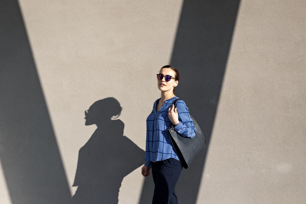 Smiling businesswoman standing near gray wall