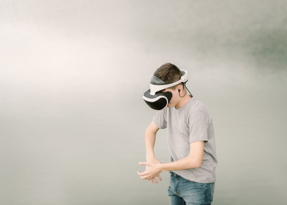 Young teenager with virtual reality glasses outdoors