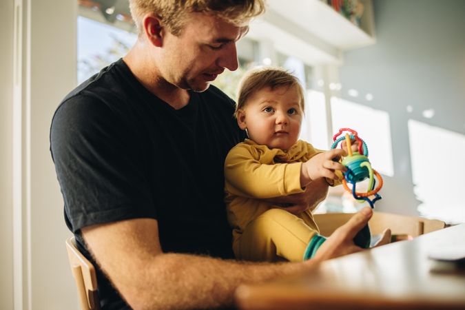 Man on paternity leave at home taking care of his son