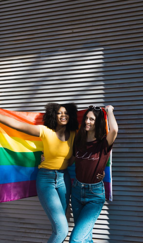 Women wrapped in LGBT flag