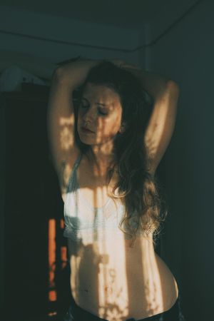 Portrait of woman in gray bra posing with floral shadow on her