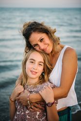 Beautiful mother and daughter embracing on beach