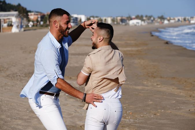 Happy gay couple dancing on seaside