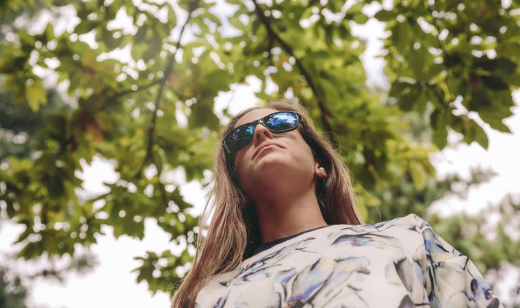 Woman with sunglasses standing over nature background