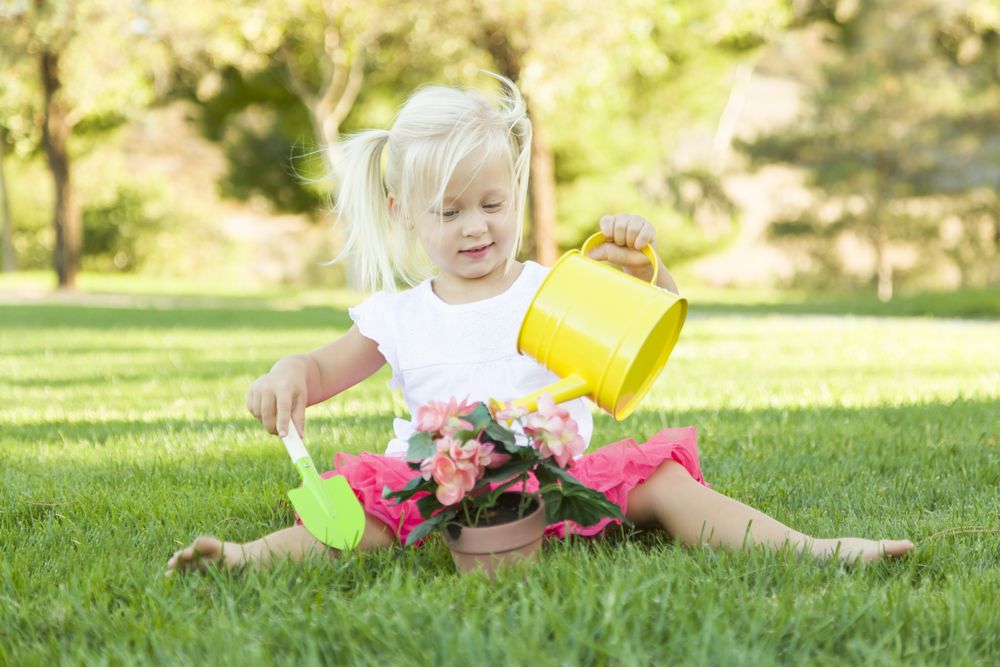 Cute Little Girl Playing Gardener with Her Tools and Flower Pot.
