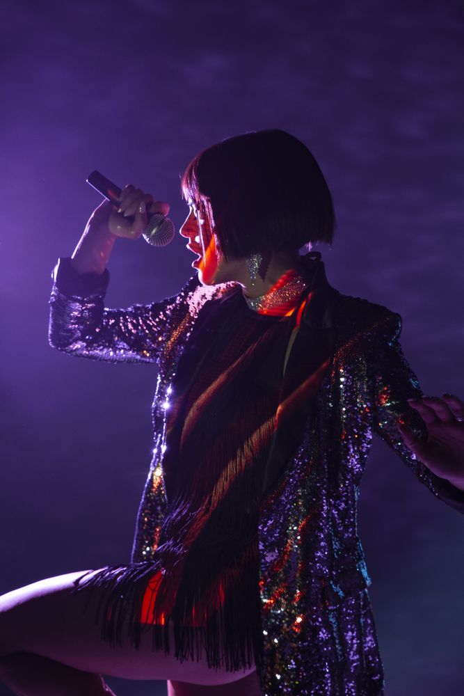 Stylish woman singing on stage