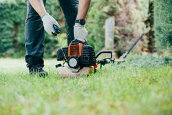 Man switching on a mechanical garden tool