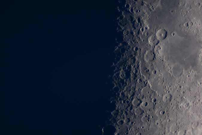 Detailed lunar craters visible near moon's shadow terminator line.
