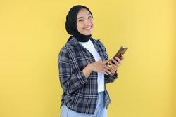 Asian Young Woman Cheerful using a Smartphone