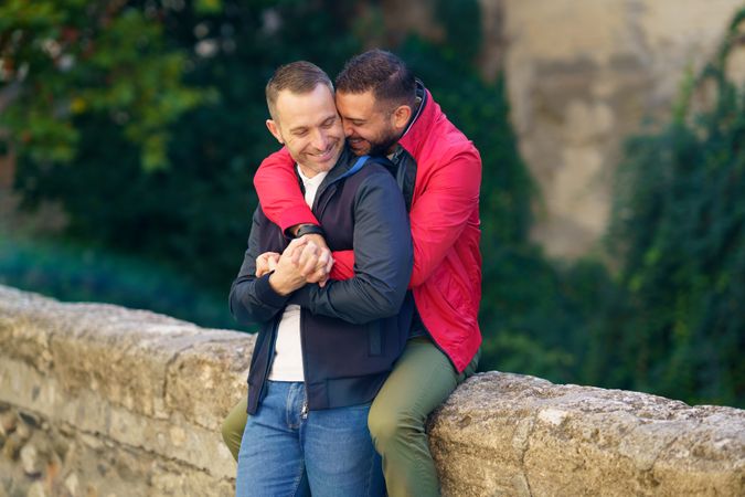 Cute male couple holding each other by the river