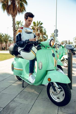 Man sitting on bike and looking to mobile phone