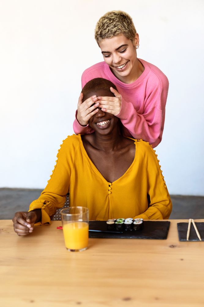 Female friends sharing surprise sushi at home