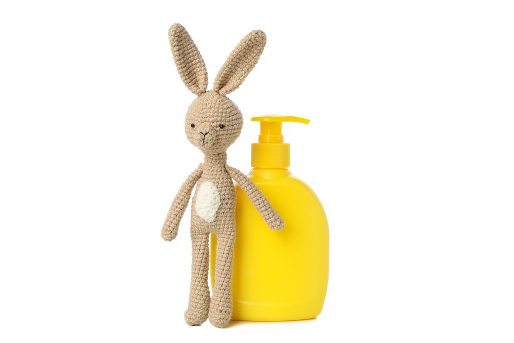 Bottle for soap and bunny doll isolated on light background