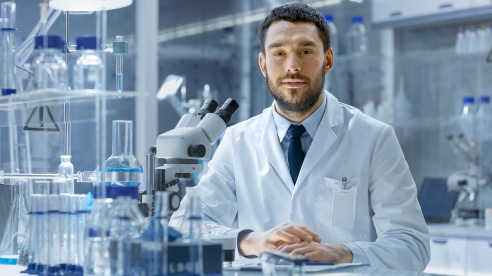 Young Male Research Looks into Camera and Smiles.