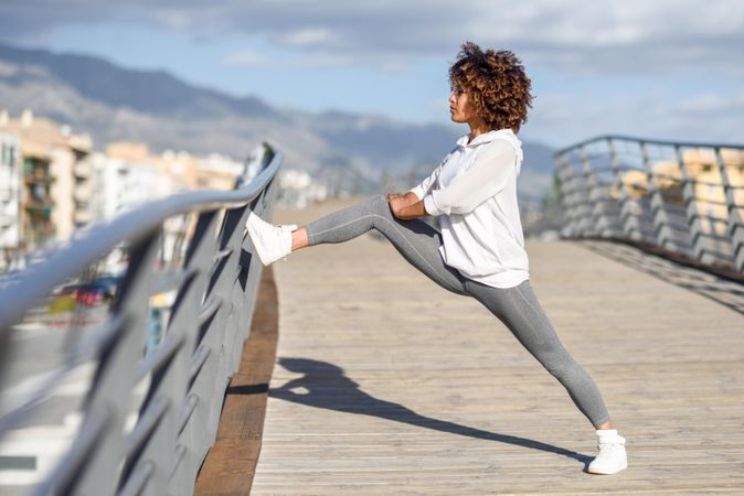 Woman stretching her legs on bridge