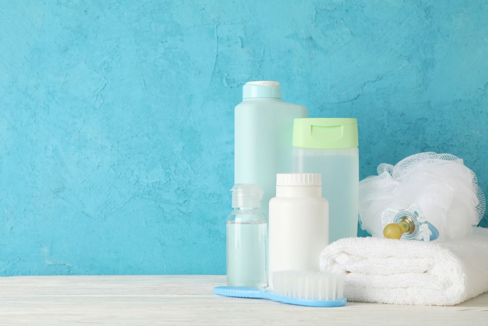 Baby hygiene accessories on wooden table against blue background