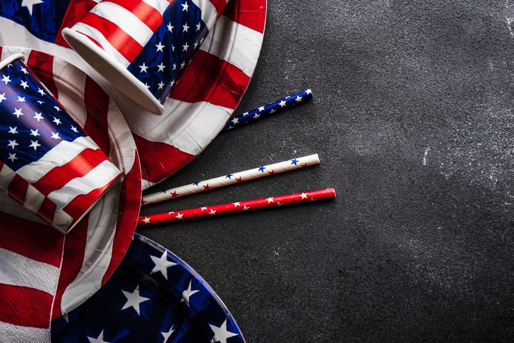 American flag plates and cups on dark table with copy space