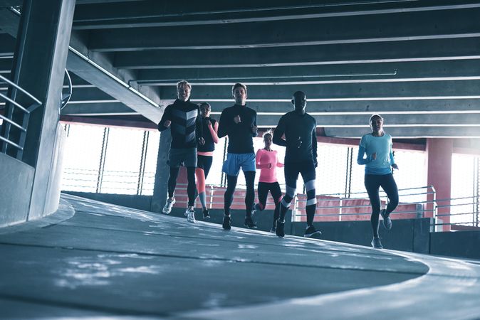 Group of sporty people running down a decline