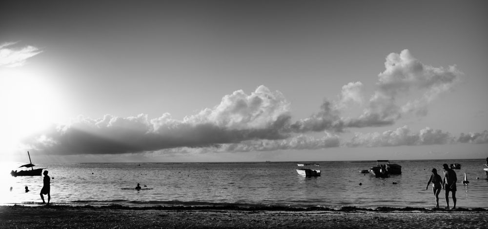 Silhouettes of people on tropical beach, b&w