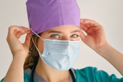 Woman putting on mask and looking at camera