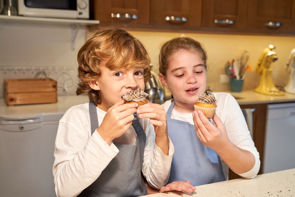 Children eating dessert in kitchen