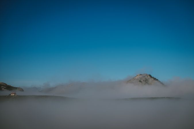 Wonderful view of blue sky above white thick clouds in valley from mountain