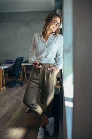 Businesswoman standing in office and looking out of window