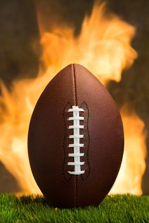 American football ball with fire at the background