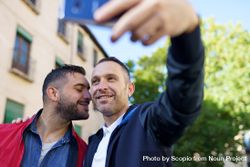 Two men taking selfie beside a building and tree 4Ao1q0