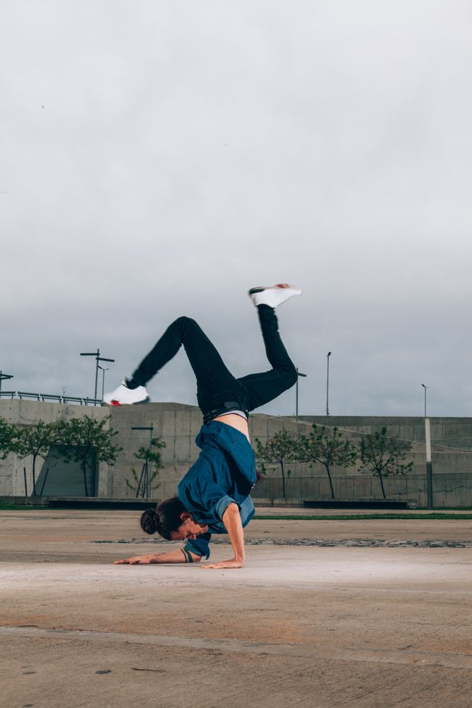 Skillful break dancer performing handstand while moving