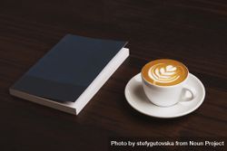 Cappuccino and navy notebook on wooden table 0ylonb