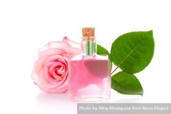 Rose water bottle on light background with rose and leaves 4A7Vm0