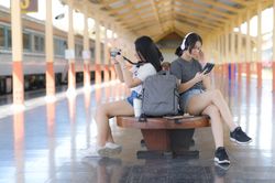Two female tourists waiting for a train on a platform for a trip