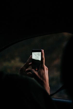 Hand taking video on smartphone in darkness