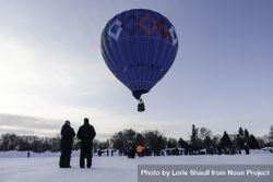 Hudson, WI, USA - February 8th, 2020: A blue hot air balloon lifting off on a winters day 4AlPm5