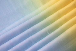 Gradient colorful folded fabric background texture. blue yellow and green.