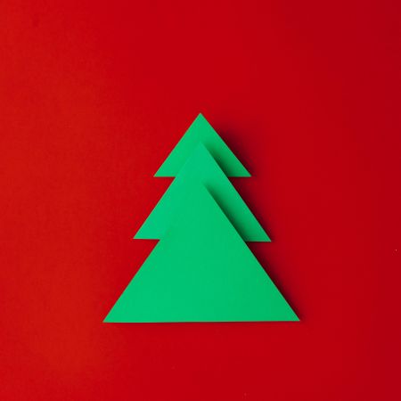 Minimal paper art style folded paper Christmas tree on red background