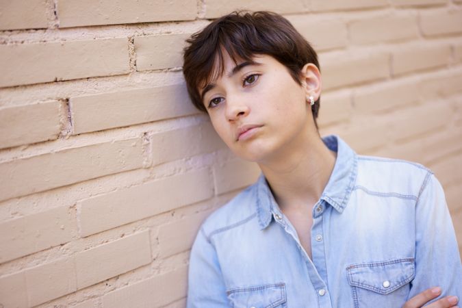 A Young Person Engaged in Contemplation as They Lean Against a Wall, Deep in Thought