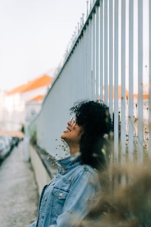Happy Black female by metal fence