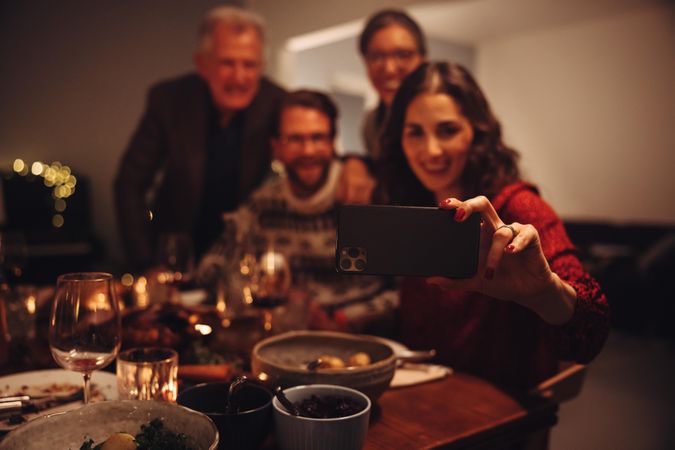 Woman taking selfie with family on christmas eve