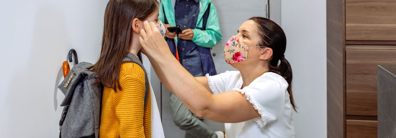 Mother putting the mask on her daughter