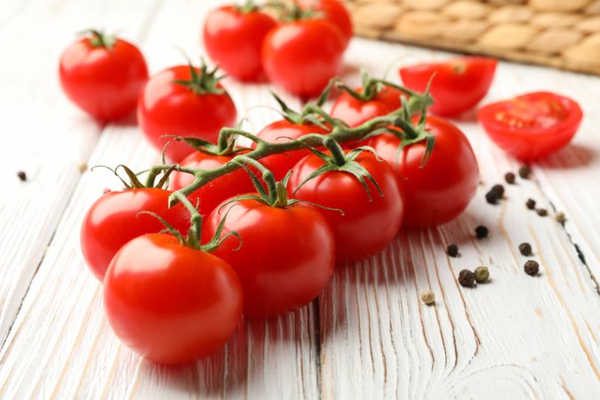 Tomatoes, pepper and basket on wooden background, close up