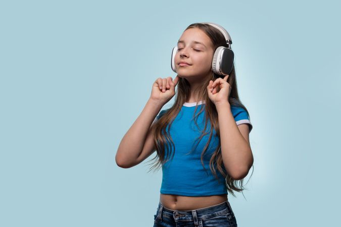 Girl with long hair enjoying music with eyes closed.