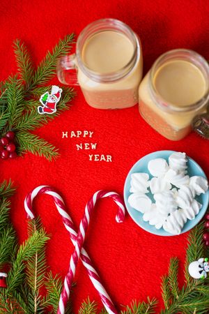 Christmas tree, candy, coffee marshmellou on a red background. The inscription Happy New Year