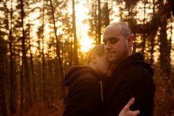 Men hugging in forest at sunset