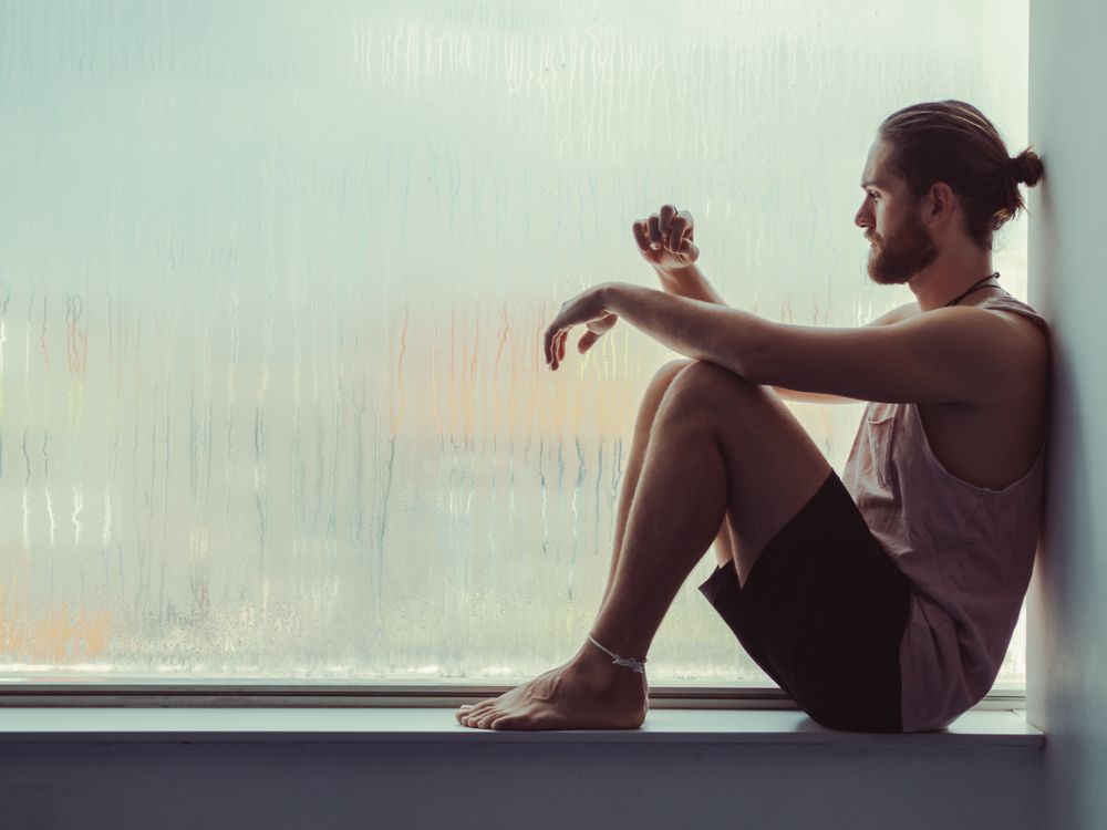 Man in mindfulness on window sill